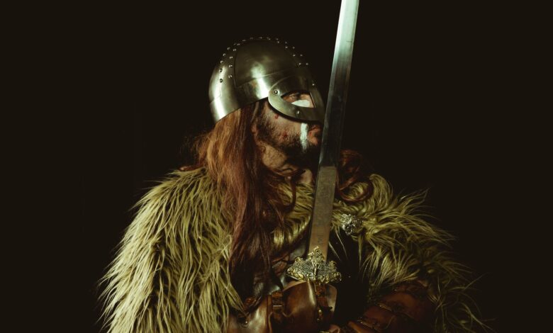 A Viking warrior in armor holding a sword, showcasing historical attire.
