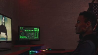 A cybersecurity professional monitors data systems in a dark room, emphasizing protection and vigilance.