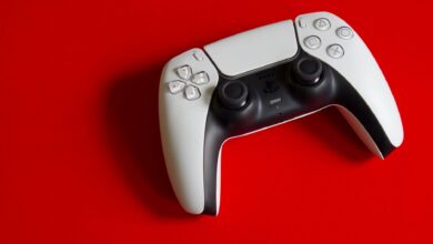 White DualSense controller for PlayStation 5 on a striking red backdrop, emphasizing modern gaming technology.