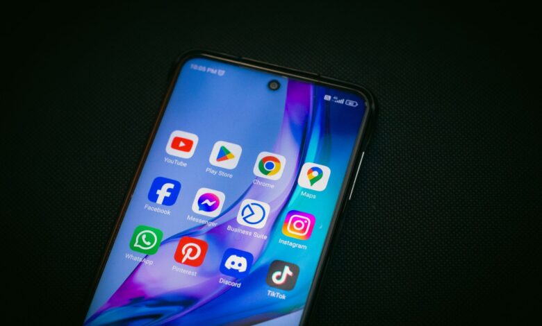 Close-up of a smartphone screen showing popular app icons like YouTube, Maps, and TikTok on a black background.