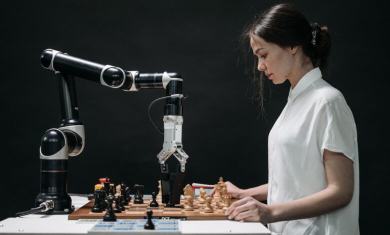 A robot and woman engage in chess, showcasing technology and strategic thinking.