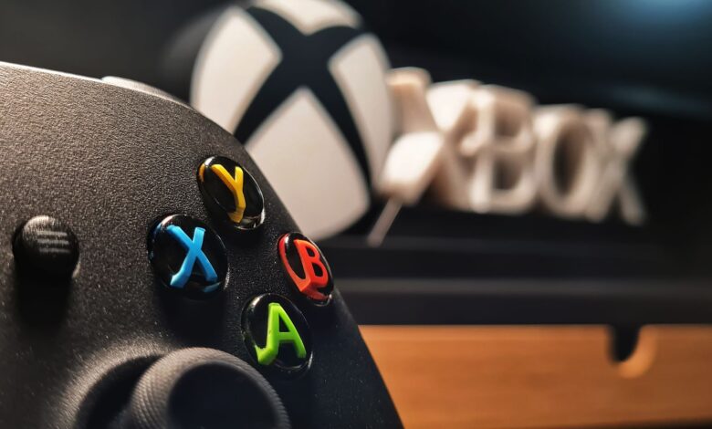 Detailed view of Xbox gaming controller with vibrant buttons displayed indoors.