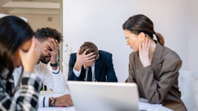 A group of stressed business professionals in an office setting, overwhelmed by work.