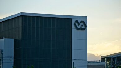 A modern building featuring a prominent VA sign, captured at sunset.