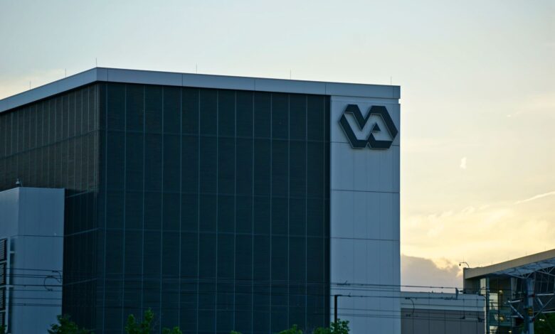A modern building featuring a prominent VA sign, captured at sunset.