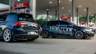 Two customized Volkswagen GTIs parked at a gas station under bright lights.