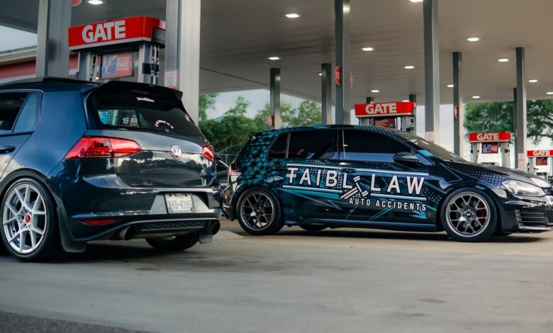 Two customized Volkswagen GTIs parked at a gas station under bright lights.