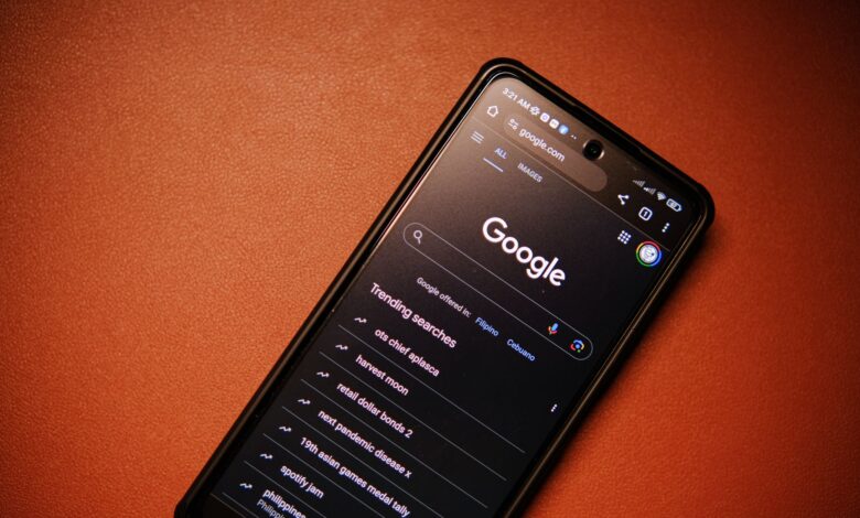 A smartphone displaying Google Search trends on a table at night.