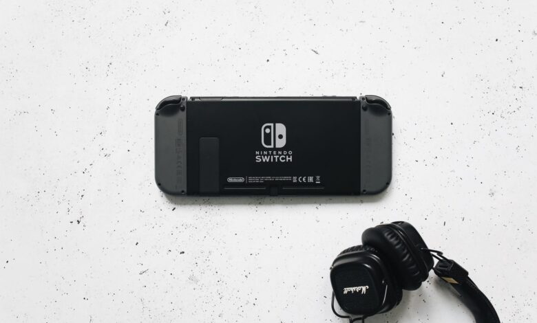 Nintendo Switch and headphones on a minimalist marble background, perfect for gaming content.