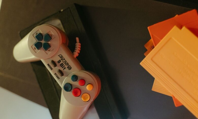 A vintage 8-bit game controller with colorful buttons next to classic game cartridges.