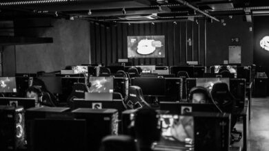 Black and white view of an active esports gaming studio with players immersed in video games.