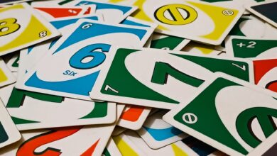 A vibrant display of Uno cards scattered in a random pile, showcasing various numbers and colors.