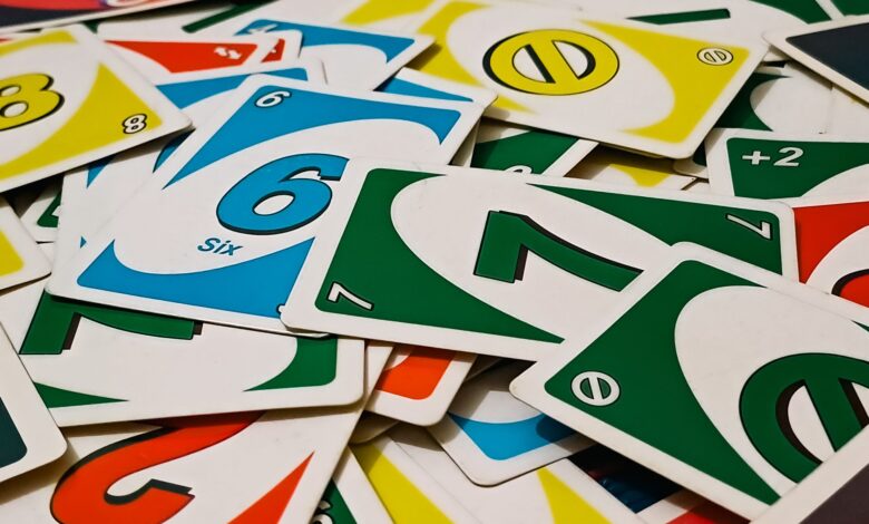 A vibrant display of Uno cards scattered in a random pile, showcasing various numbers and colors.
