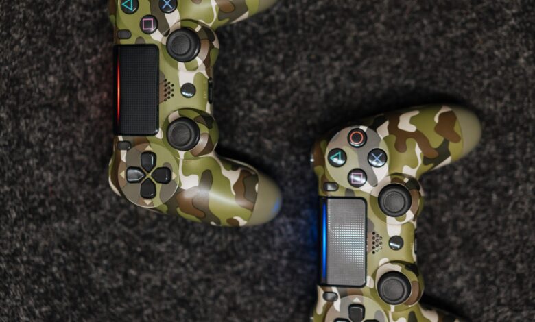 Close-up view of camouflage-patterned game controllers on a dark carpet background.
