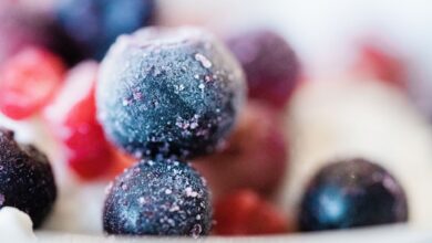 Frozen blueberries and fruits in a close-up shot, showcasing frost and vibrant colors.