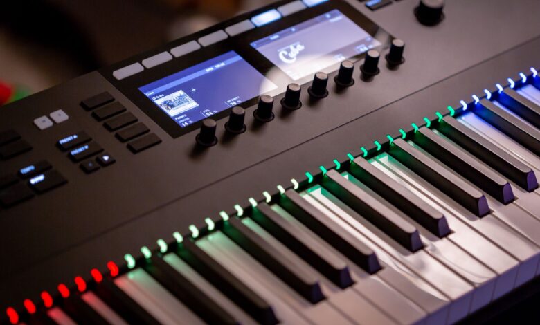Close-up of an electronic keyboard with colorful illuminated keys in a studio setting.