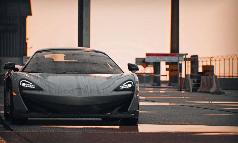 Elegant supercar with wet reflections parked on an urban street, showcasing modern design under a muted sky.