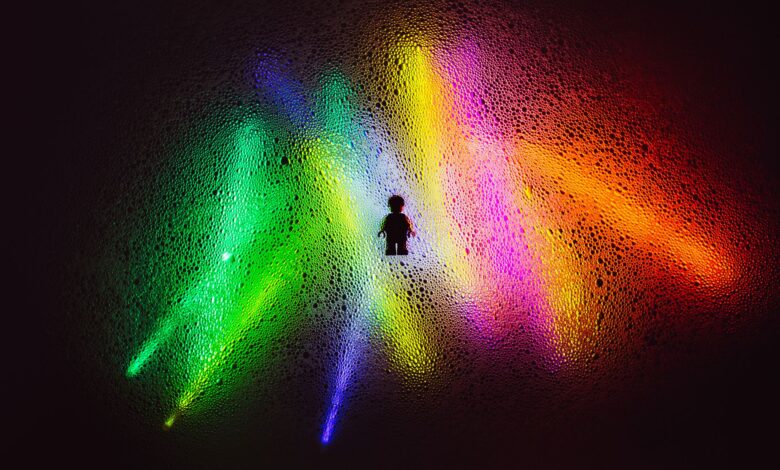 Vibrant abstract scene with a silhouetted Lego figure amid colorful light effects and textures.
