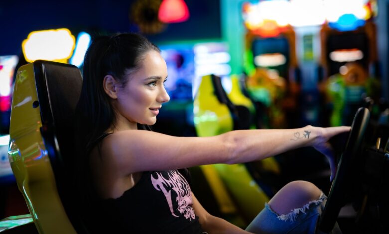 A young woman immersed in playing an arcade racing game in a vibrant retro arcade setting.