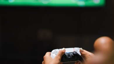 Close-up of hands holding a modern video game controller while gaming.