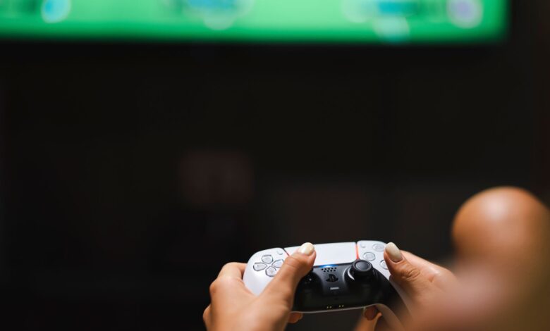 Close-up of hands holding a modern video game controller while gaming.