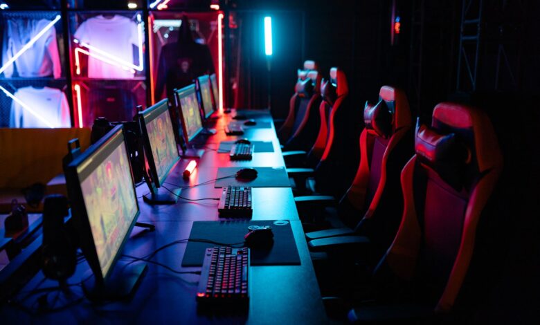 High-tech gaming setup with PCs, RGB lighting, and gaming chairs in a gaming house.