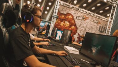 A young male gamer intensely focused during an esports event at an indoor gaming convention.