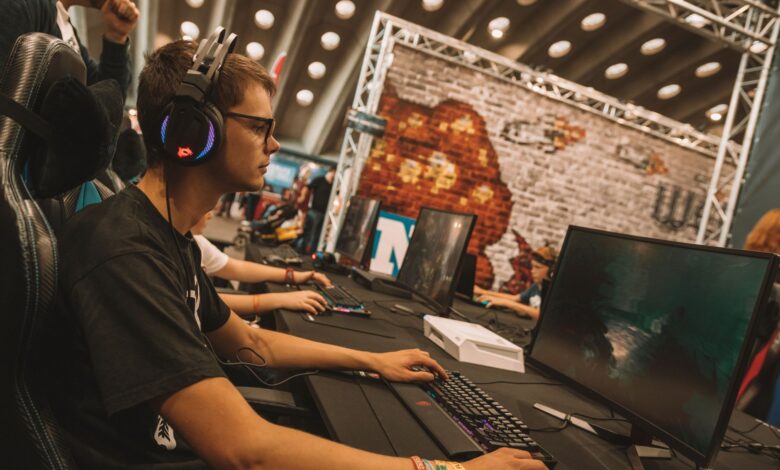 A young male gamer intensely focused during an esports event at an indoor gaming convention.