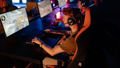 A group of gamers focused on a competitive match in a dimly lit esports arena.