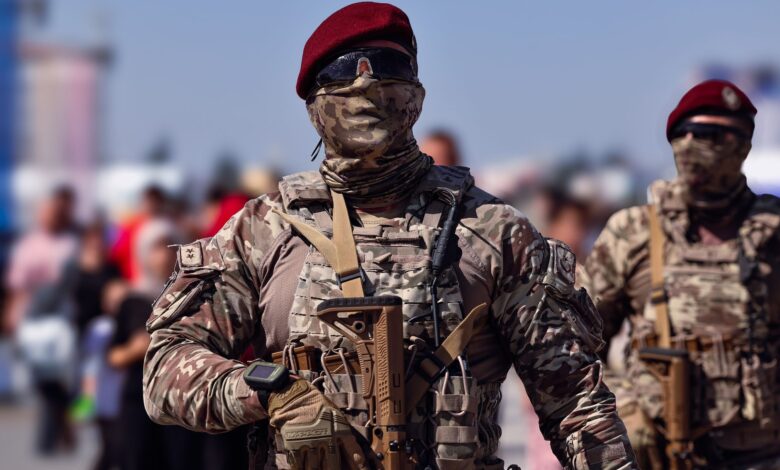 Armed Turkish commandos in camouflage gear marching outdoors during the day.