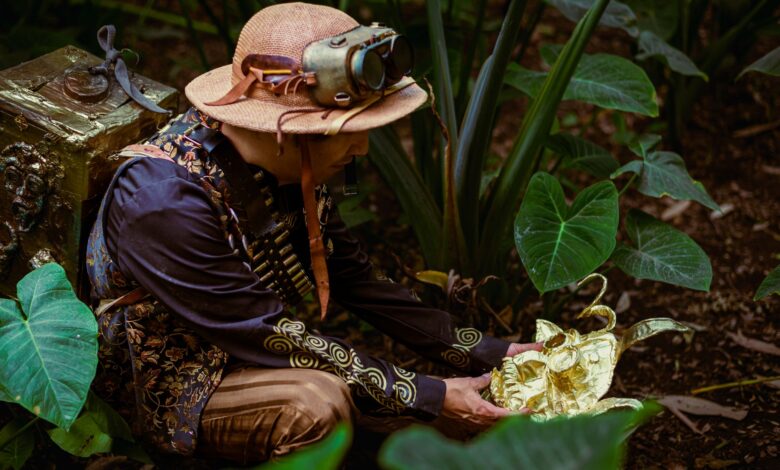 A man in steampunk attire discovers a golden artifact amidst lush green forest foliage.
