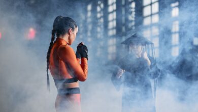 Two cosplayers in martial arts poses creating an intense and dramatic scene.