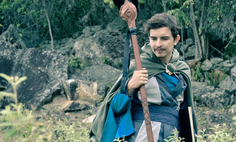 Man wearing medieval cosplay costume holding staff in a forest setting in Colombia.