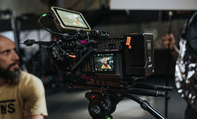 Close-up of a professional film camera setup with crew on a movie set, capturing behind-the-scenes action.