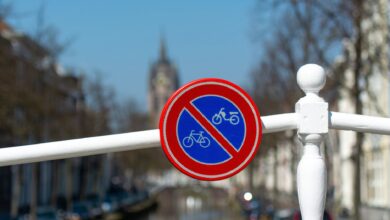 A no bicycles sign on a bridge in Delft, the Netherlands, by a canal on a sunny day.