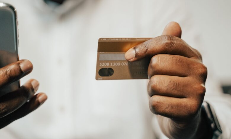 Person using a smartphone and credit card for online shopping or payment.