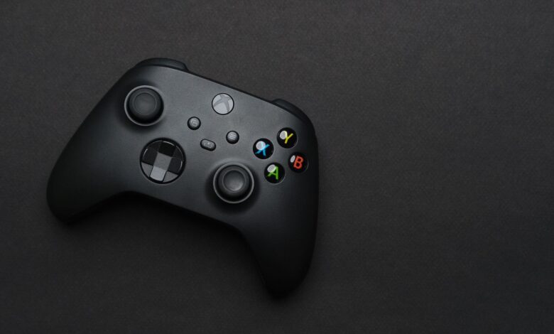 Closeup of a black gaming controller on a dark backdrop, perfect for tech themes.
