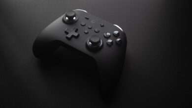 Modern black game controller on a dark surface, perfect for tech and gaming themes.