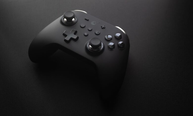 Modern black game controller on a dark surface, perfect for tech and gaming themes.