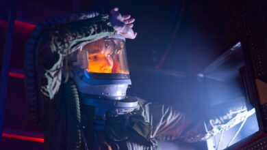 A woman in a spacesuit explores a futuristic spacecraft interior with dramatic lighting.