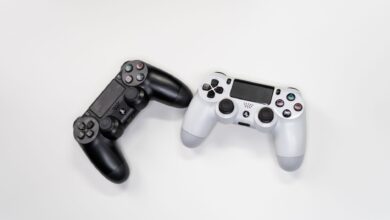 Flat lay of black and white gaming controllers against a white backdrop, perfect for gaming enthusiasts.