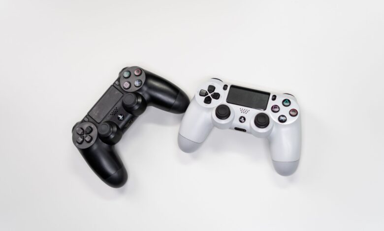 Flat lay of black and white gaming controllers against a white backdrop, perfect for gaming enthusiasts.