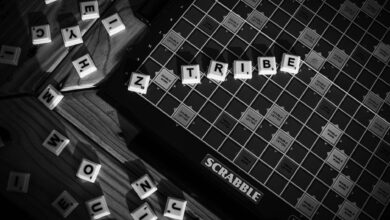 Monochrome image of a Scrabble board with letter tiles forming 'TRIBE'.