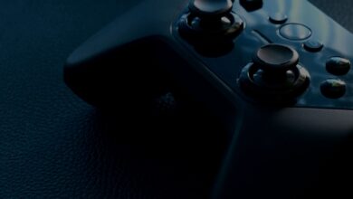 A detailed macro shot of a black game controller with reflections, emphasizing technology and gaming.