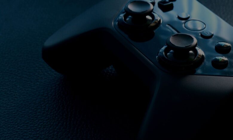 A detailed macro shot of a black game controller with reflections, emphasizing technology and gaming.