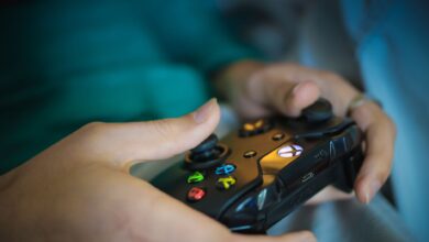 Hands gripping a modern wireless gaming controller indoors. Perfect for tech enthusiasts.