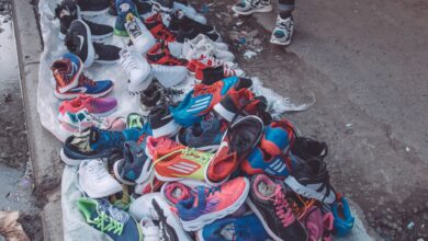 An array of vibrant sneakers displayed by a street vendor on a city pavement.