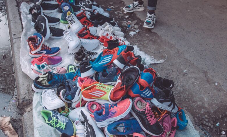 An array of vibrant sneakers displayed by a street vendor on a city pavement.