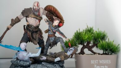 Detailed figurines in an action pose next to a miniature bonsai tree in a pot with 'Best Wishes' text.