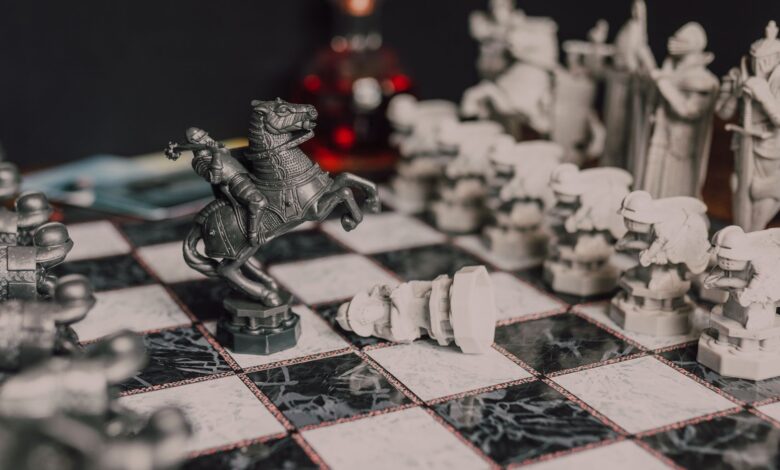 Close-up of a fantasy-themed medieval chess set with intricate details, highlighting a knight piece.